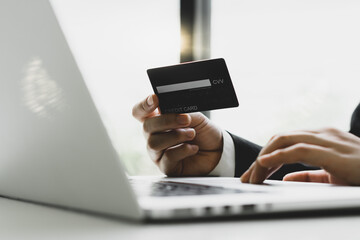 Hands holding credit card and using laptop. Online shopping