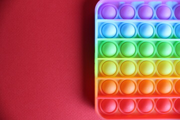 Toy anti-stress popit simple dimple on a red background with a place to stand up text and copyspace