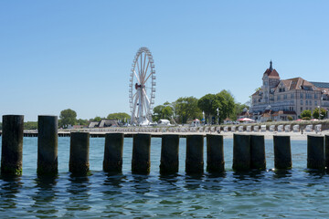 View of the coast from the water, a summer day on the beach with beach chairs, ferris wheel and...
