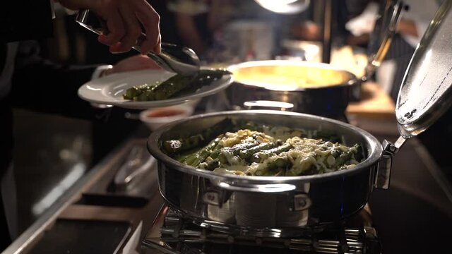 Chef preparando variedad de platos en un buffet