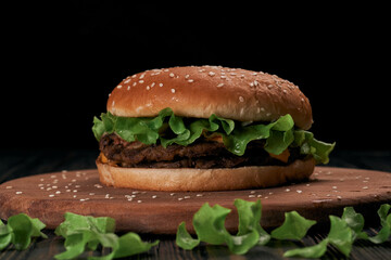 image of a burger with a chicken cutlet on a wooden board.