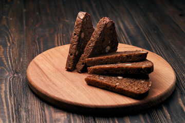 slices of rye bread with pine nuts on a wooden board.