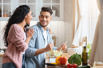 Portrait Of Romantic Middle Eastern Spouses Cooking Healthy Food In Kitchen Together