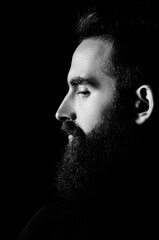 Low key dramatic photo of a bearded man
