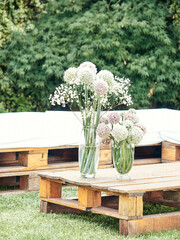Table made with wooden pallets decorated with a vase with flowers