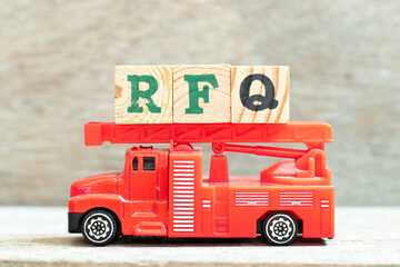 Fire ladder truck hold letter block in word RFQ (abbreviation of request for quotation) on wood...