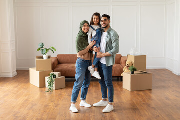 Happy muslim family looking at camera, posing on moving day