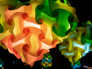 Colorful lights in the shape of a geometric heart in a plastic lantern at night.