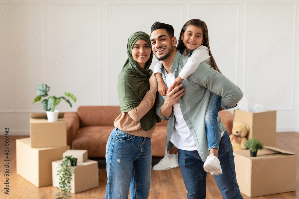 Wall mural happy muslim family looking at camera, posing on moving day