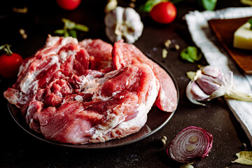 Fresh pork with vegetables on dark background. Fresh meat kitchen - obrazy, fototapety, plakaty