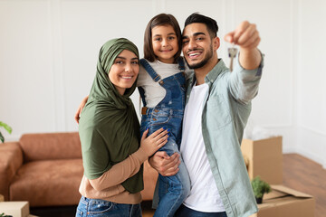 Happy muslim family showing keys of their apartment