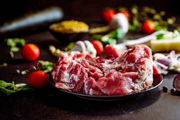 Fresh pork with vegetables on dark background. Fresh meat kitchen