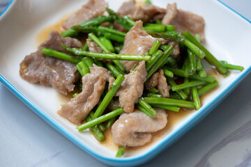 Asparagus sauteed with pork in a white ceramic dish