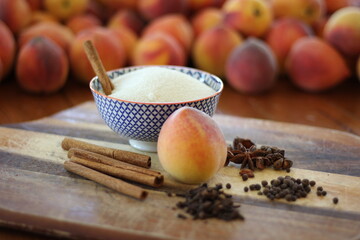 Peaches and spices on cutting board and table
