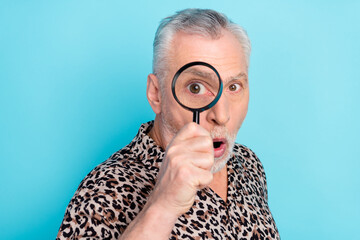 Photo of shocked amazed old man hold hand magnifier look zoom eye isolated on pastel blue color background