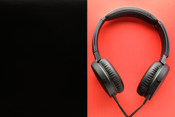 Black wired Headphones on a red and black background. Entertainment concept