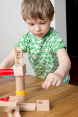 Naklejka premium Cascade marble run. Kid plays with glass marble and bell. Happy playful look.