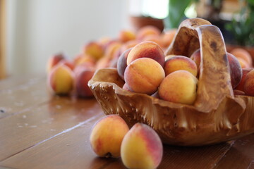 Peaches in wood basket on table
