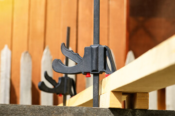 Clamping with clamps pistol type wooden lath. Clamp joiner black with red overlays. Fastening parts.