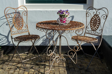 Vintage metal bistro table and chairs set in outdoor cafe