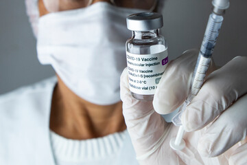 Médica segurando frasco da vacina covid-19