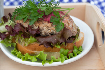a plate with a sandwich with salad and cutlet.