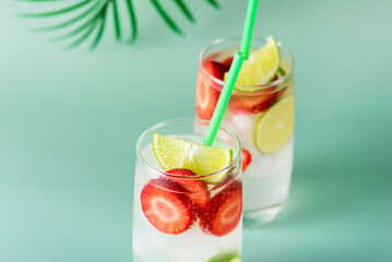Refreshing Summer Drink with Strawberry Lime and Ice in Glasses on Green Background