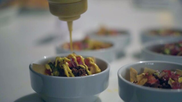 chef colocando salsa a una ensalada mexicana en un restaurante