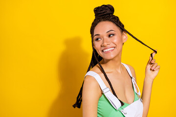 Photo of sweet pretty dark skin lady wear green crop top smiling arm braid looking empty space isolated yellow color background