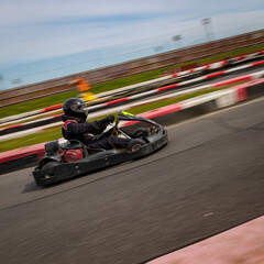 Fototapeta premium A panning shot of a racing kart as it circuits a track.