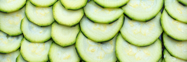 Fresh raw sliced zucchini courgettes panoramic background