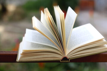 Open book in a garden. Selective focus.