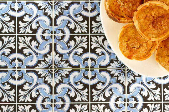 Top view of Traditional Portuguese chessecakes called Queijada de Sintra on portugueses tiles background with copy space