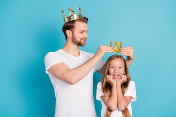 Photo of handsome guy put crown on head amazed cheerful girl hands on cheeks isolated on blue color background