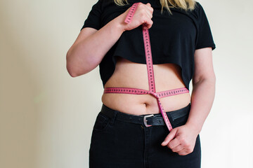 Woman measuring her waistline fat tummy. Concept of the diet, the body measures, body part of a fat...