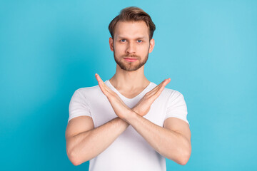 Portrait of focused young person crossed arms show stop symbol look camera isolated on blue color...