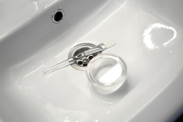 cosmetic brush and glass bowl in the sink. skin care procedures at a beautician. beauty products