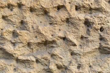 Rough wall plaster background texture. Dirty building exterior pattern of a surface. Stucco material structure on a facade.