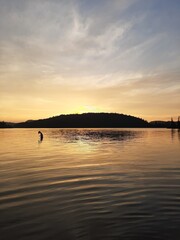 Gorgeous sunset landscapes over water and mountain. Silhouette of a femelle inside of the lake. 