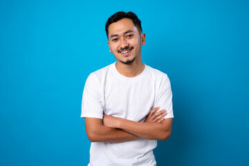 handsome young man with thin beard smiling confidently on blue background