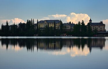 Strbske pleso, lake and small town, in the evening. Buildings and trees reflecting in the lake. High Tatras, Slovakia.