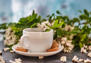 Cup of coffeel and acacia closeup. Nutrition. background with a cup of Coffee and acacia flowers.