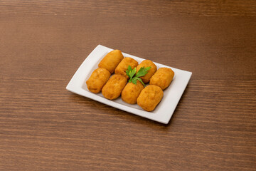Eight cream-filled croquettes with freshly fried boletus ready to eat as tapas
