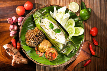 Indonesian cuisine, Grilled Aromatic Rice wrapped in Banana Leaves with Beef Tripe and Fresh Salad - 437085577