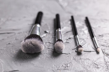 Top view of make-up brushes on grey background