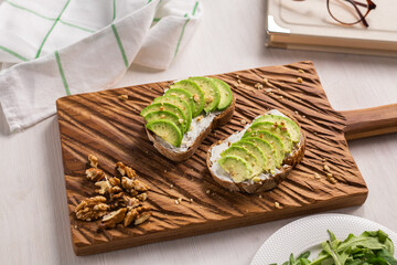 Avocado sandwich on dark rye bread made with fresh sliced avocados from above. Breakfast concept.