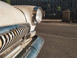The headlight of an old Soviet car. Details and fragments of the body of a retro car. Vintage.