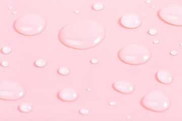 Dropper of cosmetic liquid transparent gel with bubbles on pink background