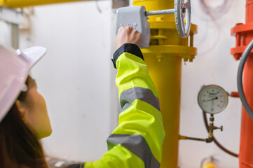 Asian engineer wearing glasses working in the boiler room,maintenance checking technical data of heating system equipment,Thailand people