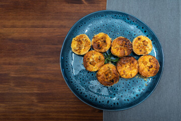 Blue ceramic round plate with baked goods on a dark wood table